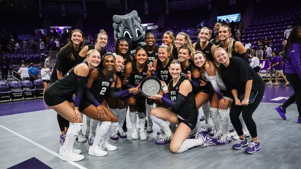 TCU Volleyball celebrates a win over SMU with an iron skillet that reads "Beat SMU"