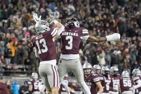 Ryder Meyer (13) and TraJon Cotton (3) of the Montana Grizzlies celebrate during a college football playoff game between the Montana Grizzlies and the Southeast Missouri State Redhawks at Washington-Grizzly Stadium in Missoula, Montana on November 27th, 2022.