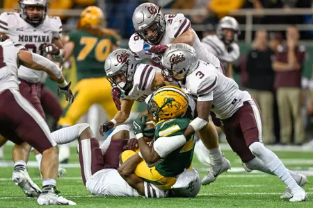 TraJon Cotton #3 of the Montana Grizzlies tackles TaMerik Williams #22 of the North Dakota State Bison in the fourth quarter at the Fargodome on December 3, 2022 in Fargo, North Dakota.
