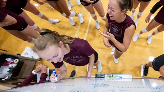 Sarah Ashley, Carly Anderson writing goals on whiteboard
