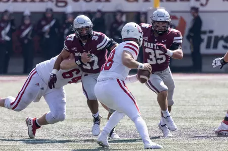 Braxton Hill #35 and Marcus Welnel #37 of the Montana Grizzlies rush Carson Camp #18 of the South Dakota Coyotes during a college football game against the University of South Dakota Coyotes at Washington-Grizzly Stadium on September 10, 2022 in Missoula, Montana.