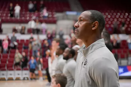 Montana Grizzlies head coach Travis DeCuire looks on during the national anthem before a college basketball game between the Montana Grizzlies and Western Washington Vikings at Robin Selvig Court inside Dahlberg Arena on October 21, 2023 in Missoula, Montana.