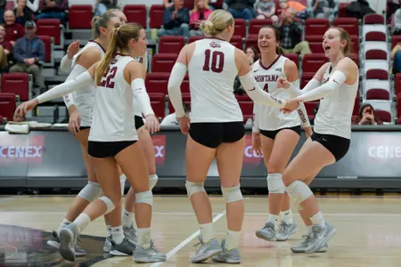 The Montana Grizzlies celebrate after scoring a point during the fourth set of a college volleyball match between the Montana Grizzlies and the Northern Arizona Lumberjacks at Dahlberg Arena on November 2, 2023 in Missoula, Montana.
