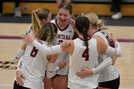 The Montana Grizzlies celebrate after scoring a point during the second set of a college volleyball match between the Montana Grizzlies and the Northern Arizona Lumberjacks at Dahlberg Arena on November 2, 2023 in Missoula, Montana.