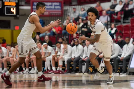 Brandon Whitney #12 of the Montana Grizzlies passes the ball to Josh Vazquez #3 during the first half of a game against the Montana Tech Orediggers at Robin Selvig Court inside Dahlberg Arena on December 9, 2023 in Missoula, Montana.