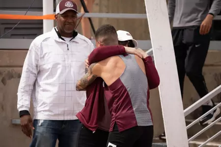Jaydon Green hugs his mother Sheri while his dad Terrence watches on following his Big Sky Championship.