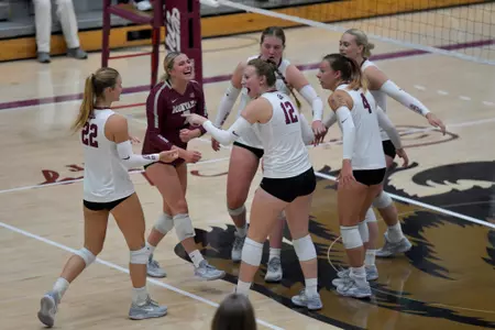 The Montana Grizzlies celebrate after scoring a point during the second set of a college volleyball match between the Montana Grizzlies and the Weber State Wildcats at Dahlberg Arena on September 20, 2023 in Missoula, Montana.