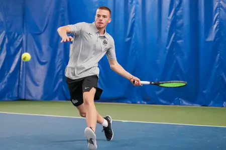 Dragos Bucurescu of the Montana Grizzlies watches the ball during a tennis match against the Whitworth Pirates at the PEAK Racquet Club in Missoula, Montana on January 20, 2024.