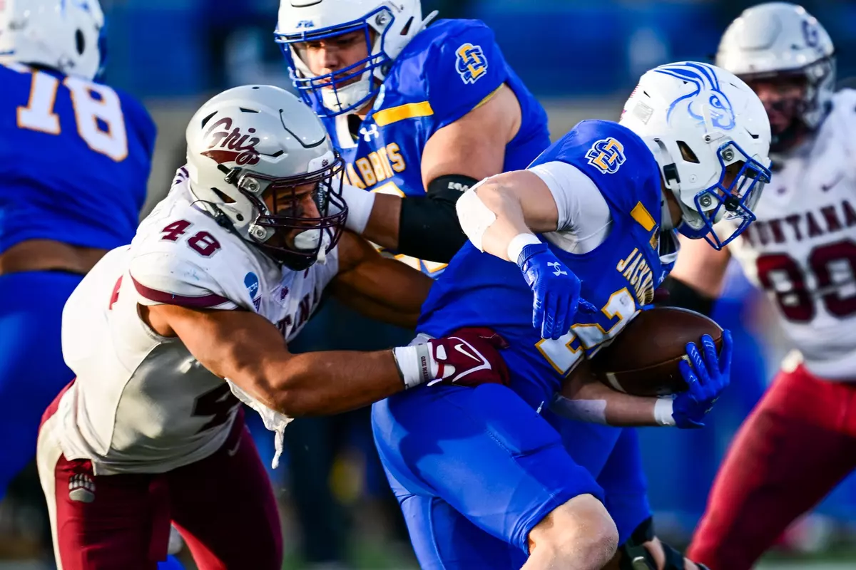 Hayden Harris #48 of the Montana Grizzlies tackles Kirby Vorhees #20 of the South Dakota State Jackrabbits during the fourth quarter at Dana J Dykhouse Stadium on December 7, 2024 in Brookings, South Dakota.