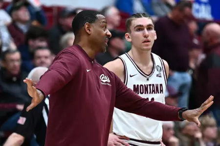 Montana Grizzlies head coach Travis DeCuire talks with Aanen Moody #11 of the Montana Grizzlies during a timeout against the Idaho State Bengals at Robin Selvig Court inside Dahlberg Arena on March 4, 2024 in Missoula, Montana.