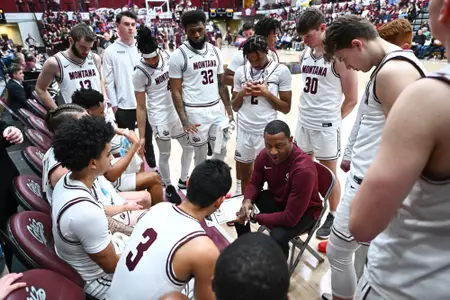 Montana Grizzlies head coach Travis DeCuire talks over a play with his team while playing against the Idaho State Bengals at Robin Selvig Court inside Dahlberg Arena on March 4, 2024 in Missoula, Montana.