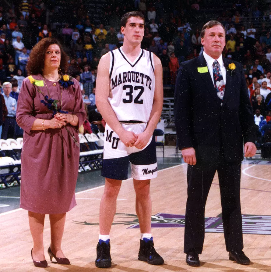 Marquette basketball player Joel Pogodzinski stands on the court with his parents, 1994.