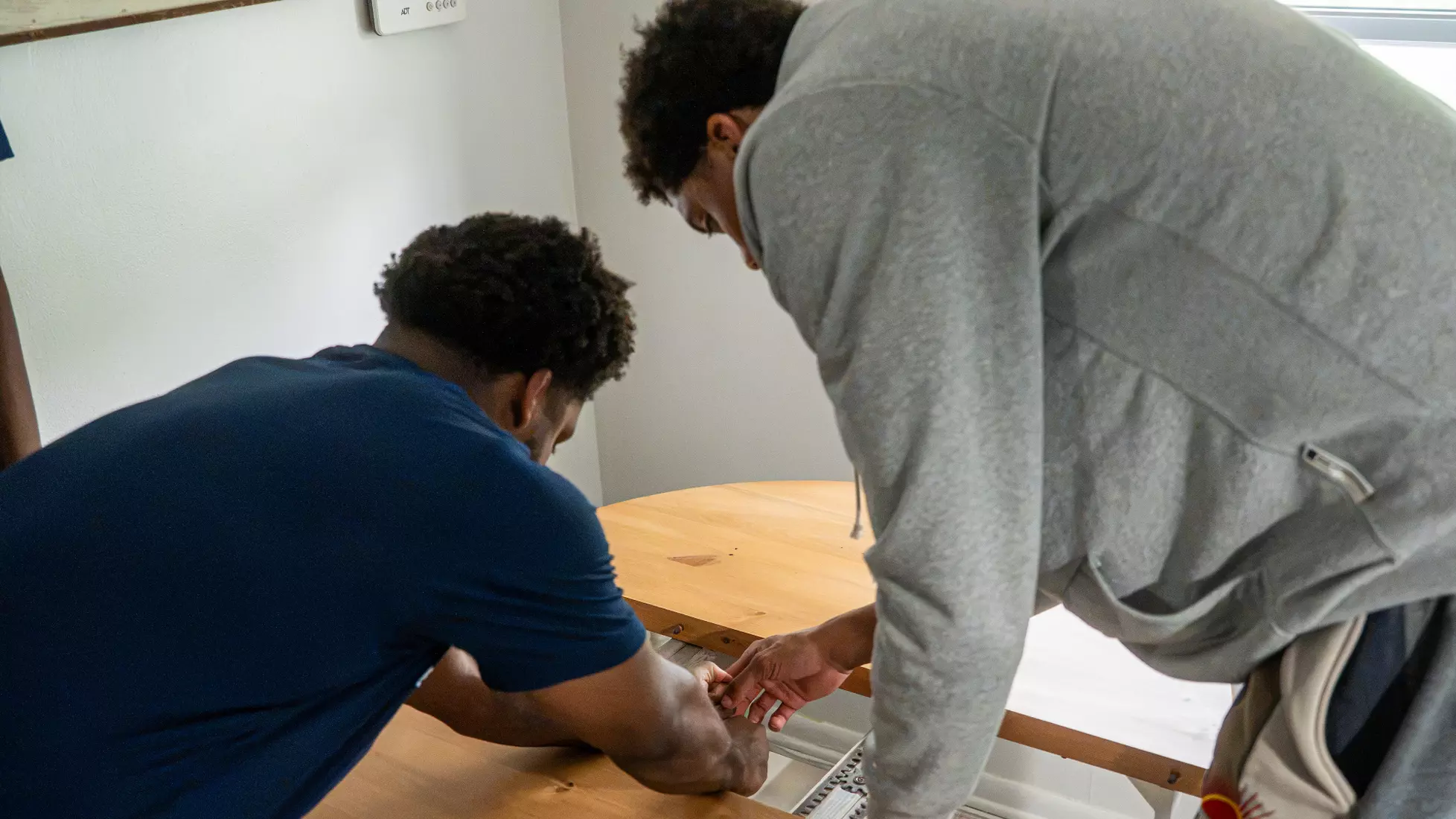 Cameron Brown and Joshua Clark put together kitchen table