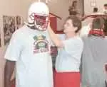 Assistant Equipment Manager Jimmy Stewart helps Jerrick Hall find the correct helmet size.