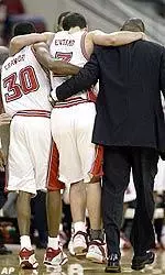 Ilian Evtimov is carried off of the court by teammate Cliff Crawford (30) and assistant coach Larry Harris.