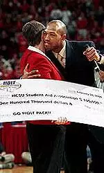 Torry Holt making the presentation to chancellor Marye Anne Fox at Sunday's basketball game.