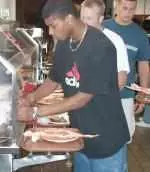 Victor Stephens loads his plate with crab legs at the football squad's Welcome Back dinner.