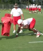 Mario Williams goes through a tackling drill while coach Greg Williams looks on