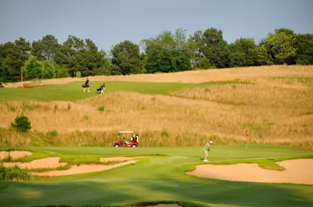 The late afternoon sun shines on golfers finishing up their rounds at Lonnie Poole Golf Course.