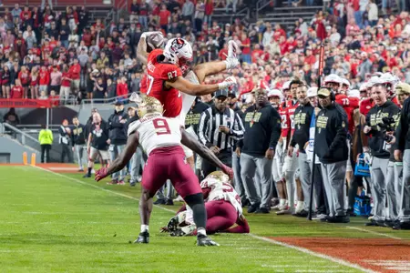 NC State Wolfpack tight end DANTE DANIELS (87) leaps over Florida State Seminoles defensive back K.J. KIRKLAND (24) and gets tackled by Florida State Seminoles linebacker OMAR GRAHAM JR. (9) during the second half of the NCAA football game between the Florida State Seminoles and the NC State Wolfpack on November 21st, 2025 at Carter-Finley Stadium in Raleigh, NC.