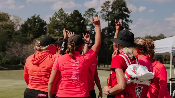 NC State women's golf huddles at UNC