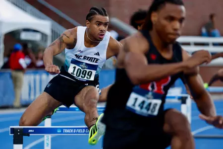 Xavier Branker jumping over a hurdle in the first round of the 400m hurdles at the NCAA East First Round