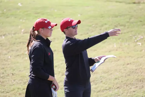 Courtney Gunter coaches Ellie Hildreth through a hole at a golf tournament