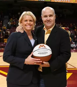 Minnesota Director of Athletics Norwood Teague presents head coach Pam Borton with a basketball commemorating her 200th win at Minnesota.