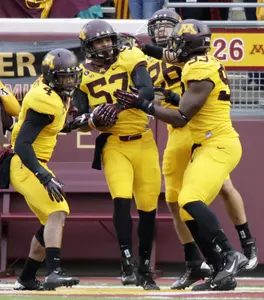 Aaron Hill (57) celebrates his touchdown on an interception against Michigan State, with teammates Keanon Cooper (4) and Ben Perry (93).
