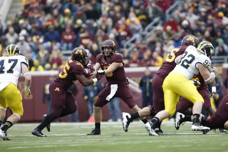 Philip Nelson hands the ball off to Rodrick Williams Jr. during Saturday's loss to Michigan.