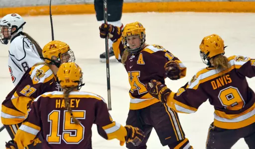 Sarah Davis (9), Kelly Terry (10), and Paige Haley (15) celebrate a Gopher goal against St. Cloud State.