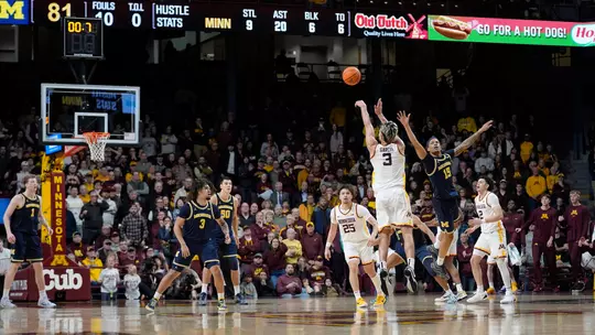 Minnesota forward Dawson Garcia (3) shoots and scores the winning 3-point basket against Michigan guard Rubin Jones (15) during overtime of an NCAA college basketball game Thursday, Jan. 16, 2025, in Minneapolis. (AP Photo/Abbie Parr)