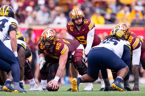 Minnesota center Greg Johnson snaps the ball to quarterback Drake Lindsey