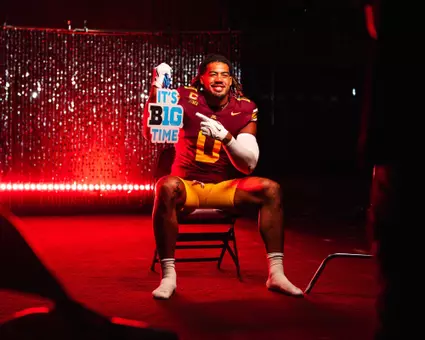 Anthony Smith poses with a sign prior to the 2026 Football Season