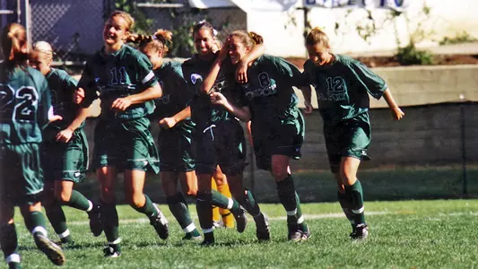 Cal Poly's women's soccer team shown in 1999 celebrating a goal