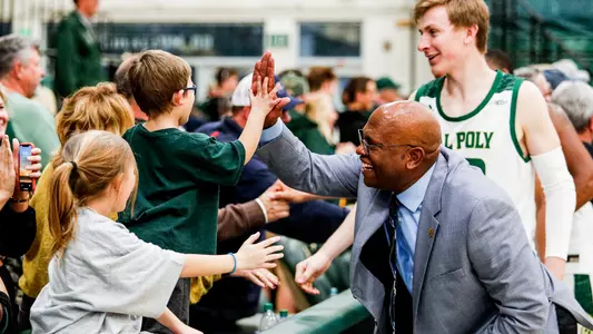 Cal Poly Head Coach John Smith celebrates a win with fans