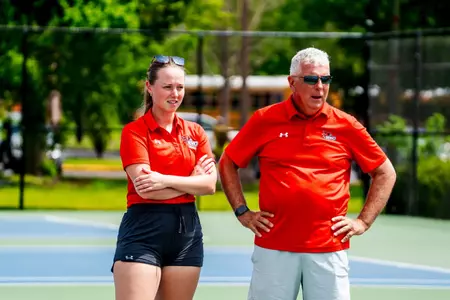 Coach Brooks and Coach Dani watching their team compete
