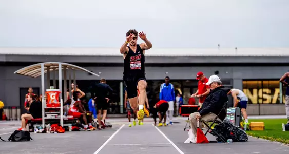 Luke Busteri explodes off the track during his triple jump attempt