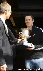 Senior captain Sebastian Mueller receives BU's fourth-ever Michalson Cup from Brown