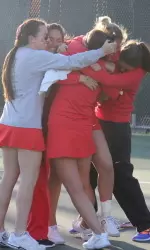 The Terriers celebrate with sophomore Sami Lieb after her three-set singles win.
