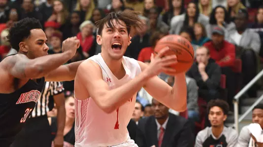 Nick Havener is driving to the hoop for a shot attempt against Northeastern.