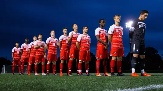 The men's soccer team's starting lineup at Harvard is lined up for the national anthem.
