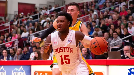 Jonas Harper drives toward the hoop from the right side with a defender behind him.