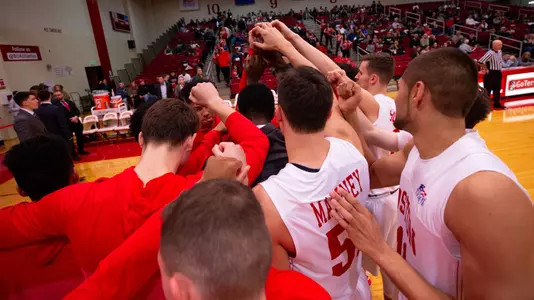 Boston University men's basketball team huddles on the court after introductions.