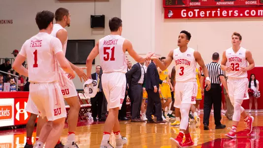 Alex Vilarino is greeted by Max Mahoney at the beginning of a media timeout as players for both teams head to their respective benches.