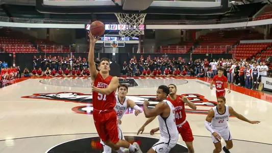 Max Mahoney goes for the layup at Northeastern with defenders surrounding him.