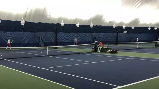 Tennis players are hitting the ball around on hard courts at the Mount Auburn Club indoor facility.