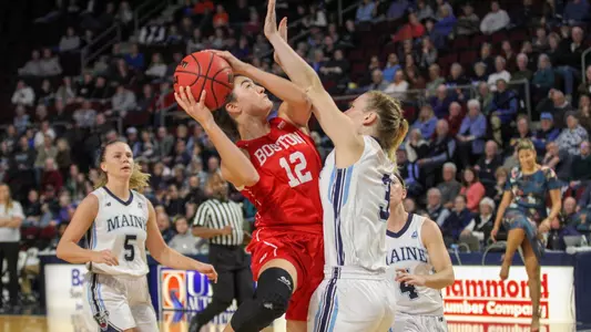 Annabelle Larnard shooting a contested shot against a Maine defender