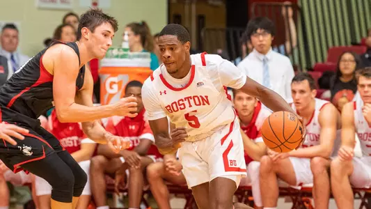 Walter Whyte dribbles the ball while guarded by a Northeastern player.