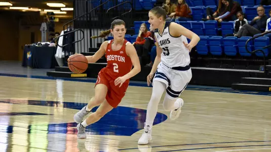 Katie Nelson dribbling past a UC Davis defender at midcourt